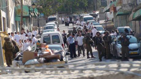 Settlers and Israeli Occupation Forces behind the gate that protesters blocked in Hebron