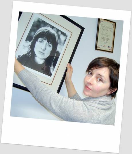 Chairman Aoife NicFhearghusa hangs up a portrait of poet Chaitln Maude in the new offices - LitPix 2011