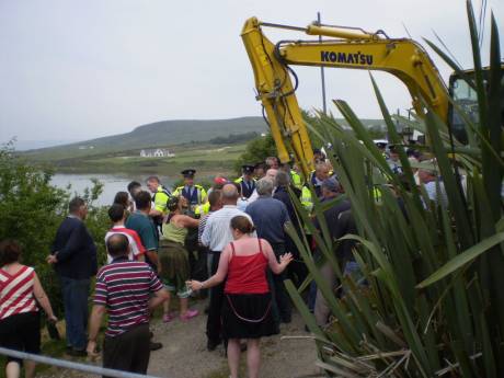 The digger is driven through the crowd. 