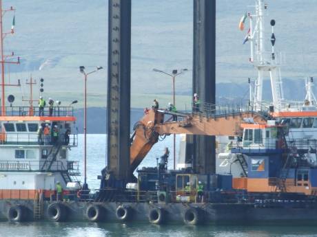 Two protesters on the joint of the digger arm