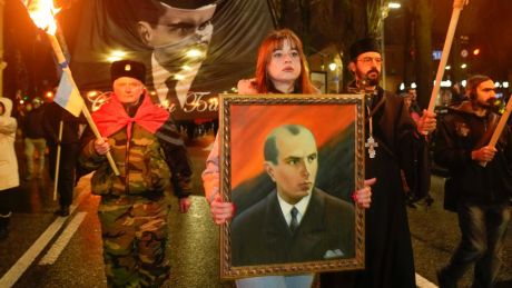 Members of various nationalist parties carry torches and a portrait of Stepan Bandera during a rally in Kyiv, Ukraine, Saturday, Jan. 1, 2022. (AP Photo/Efrem Lukatsky)