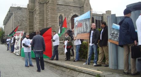 Click on image to see full-sized version Protestors line the street outside the hotel